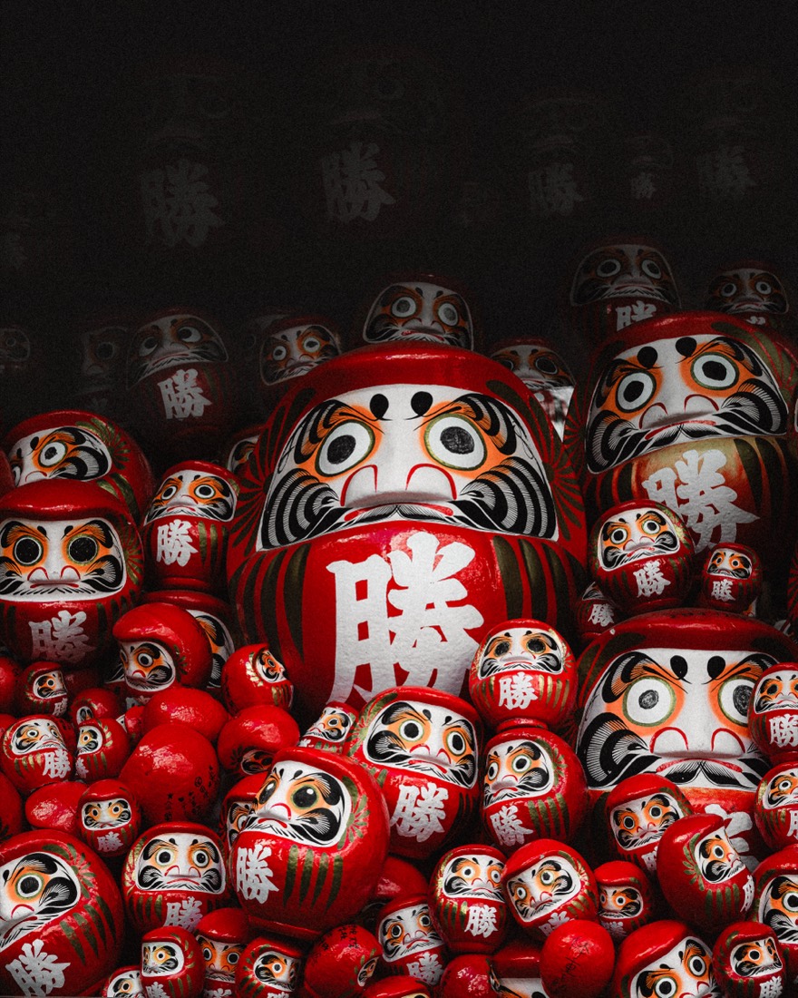 Good Fortune — a crowd of red daruma dolls stacked at a Japanese temple.