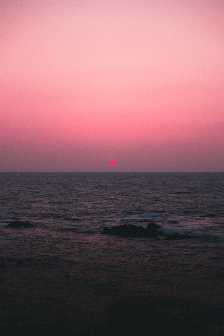 Pink Hour — a small sun sinks into a rose-coloured sea and sky.